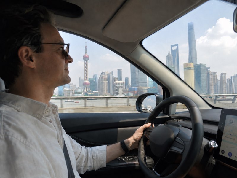 Foreigner driving legally in China with Shanghai Lujiazui skyline